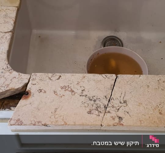 שיש שבור עם סדק ליד כיור מטבח